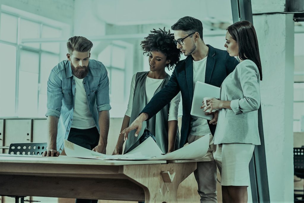Business team reviewing project plans together around a conference table.