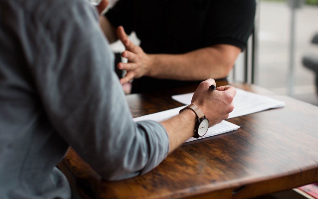 Inflection 360 client consultation with documents on a wooden table.