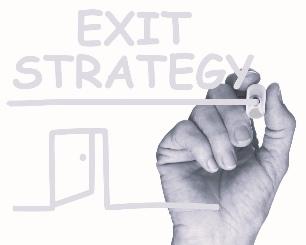 Hand writing “Exit Strategy” with a simple door icon on a whiteboard. 