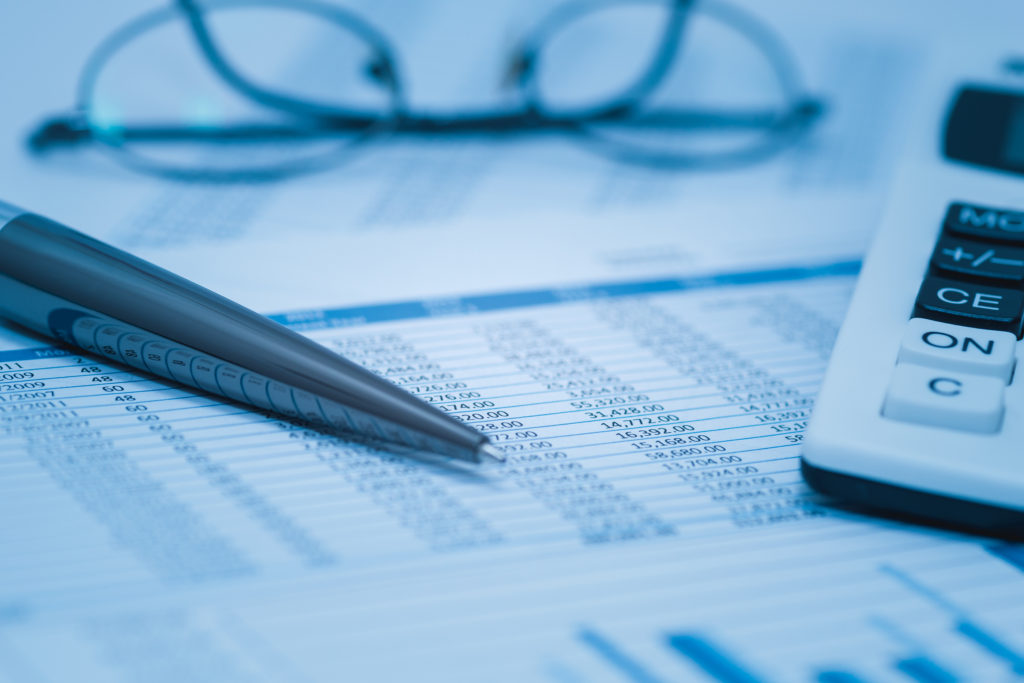 Inflection 360 financial report with pen, calculator, and glasses for healthcare valuation planning.